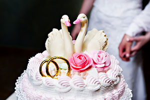 Свадебный торт с кольцами и двумя лебедями.